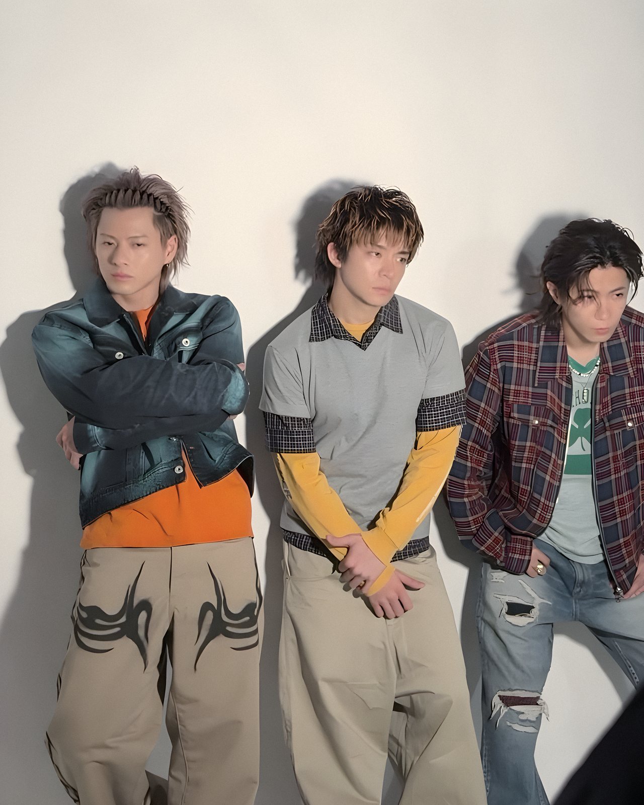 白い壁にもたれるNumber_iの3人